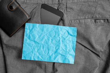 Smartphone device inside trousers front pocket with wallet and note paper