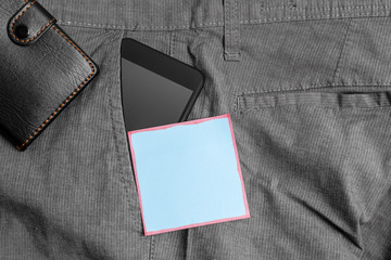 Smartphone device inside trousers front pocket with wallet and note paper