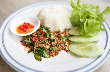 Pork Chops fried in holy basil served with jasmine rice and cucumber.