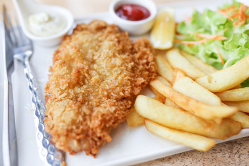 Batter fried dolly fish wrapped bread steak with salad on dish.