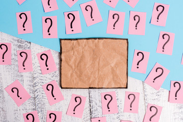 Scribbled and crumbling papers with thick cardboard above wooden table.