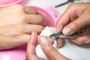 Obraz na płótnie Canvas Close up woman hand while process of manicure in nail shop. Beautiful concept. female nail manicure processing