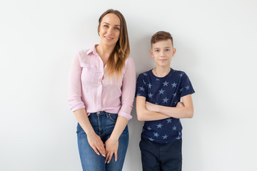 Naklejka premium Good-looking single-parent mom and teen son on white background. Cohesion, friendship and family relations.