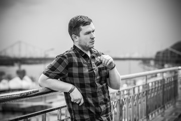 Young man with seriously mood look at the view of city, plump people concept, one in big city life. Image of guy at downtown 