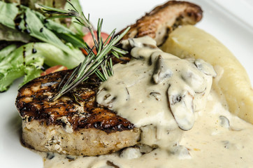 Grilled pork rib chop steak with white cream sauce mushroom top rosemary