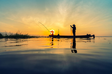 Fisherman at lake on sunset