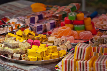 Turkish national sweets are sold at the fair. Multi-colored Asian desserts stacked on the table. Rahat lokum in bulk is sold at the festival.