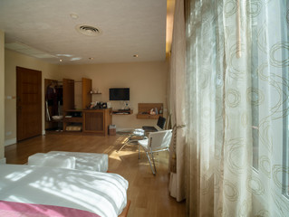 Fototapeta na wymiar Luxurious bedroom with afternoon light through white curtain.