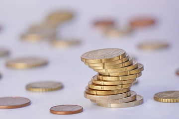 money to pay coins against blur multicolored background. Euro coins are stacked on top of each other in different positions. chart of currency rate rise or fall.