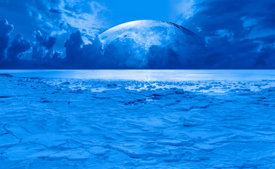 Night sky with moon in the clouds - Ice on the ocean shore at night "Elements of this image furnished by NASA"