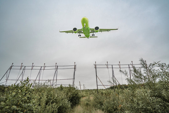 Green Airplane Flying In A Cloudy Sky