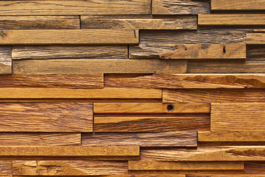 Texture of a wall of wooden bars. Stone bricks are made in the form of wooden boards.