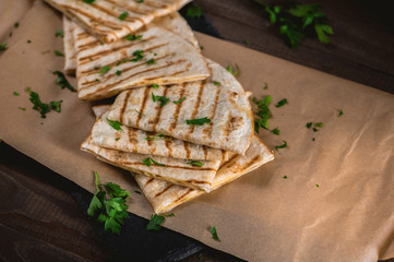 Pita bread with cheese and herbs on wooden table
