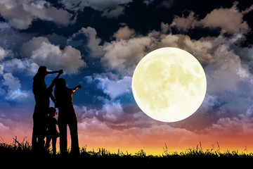 family standing on hill and watching the moon.Celebrate Mid-autumn festival together