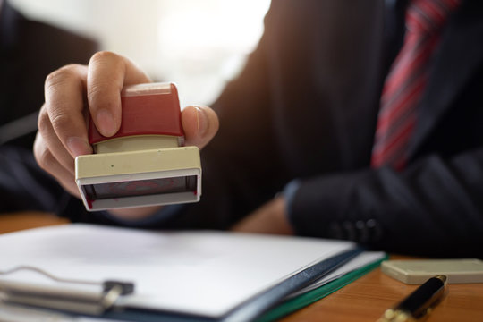 Close Up Of Hands Businessman Being Stamped With The Company Contract Of Construction Bidding .concept Of Payment