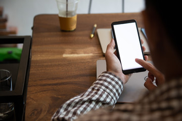 businessman hands searching for data on mock up mobile phone with at his workplace.concept