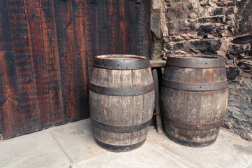 Wooden barrels standing before wooden and brick wall