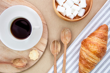 Delicious rustic breakfast with wooden dishes on a craft background. Top view coffee and croissant