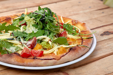 pizza with fresh vegetables on the wooden background