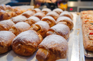 Fresh baked sweet fillded buns with sugar powder for sale at small cafe