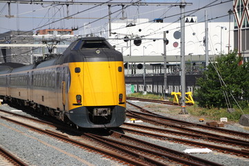 Obraz premium Yellow blue intercity train at the station of the city Gouda heading to Utrecht