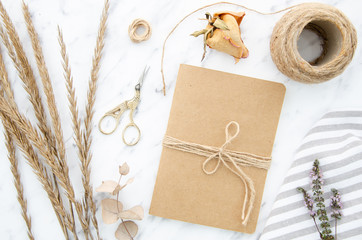Top view art and craft tools set, notebook with kraft paper cover. Lavender, twine, eucalyptus and...