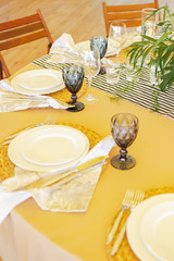 glasses, plates, a bouquet of greens with a tablecloth