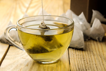 cup with tea and tea bag pyramid. close-up. on a wooden table. to make tea