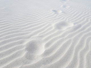 Fototapeta na wymiar Footprints on sand dune. White sand closeup