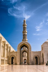 Muscat,Oman-22nd july 2019. Sultan Quaboos Grand Mosque minaret with beautiful clouds and blue sky, Islamic traditional religious architecture and landscape. - obrazy, fototapety, plakaty