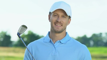Smiling golf player holding iron club posing to camera, hobby, leisure activity