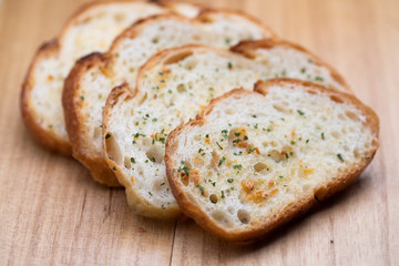 Slice garlic bread on wooden table
