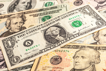 USA dollar bills. A few dollars of varying nominal values. Texture of multiple US dollar banknotes. Background from paper money. Close-up of multiple American dollar banknotes.