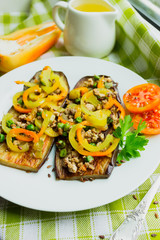 Fried eggplants with minced meat and different vegetables, flaxseed decoration, finished dish