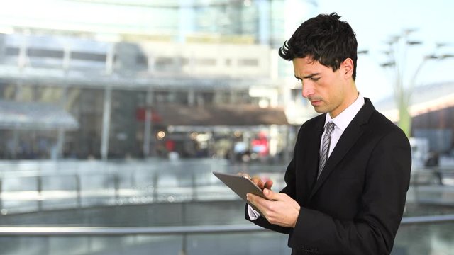 Portrait of a young businessman using a tablet computer outdoor in a modern city