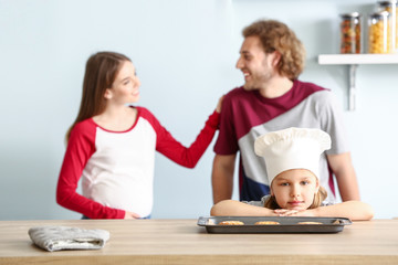 Little girl and her parents baking pastry at home