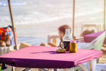 Close up lantern lamp on the table beside the beach, Atmosphere of the sea beach with flare light in the monring, Relaxing on seaside in Samed island, Thailand