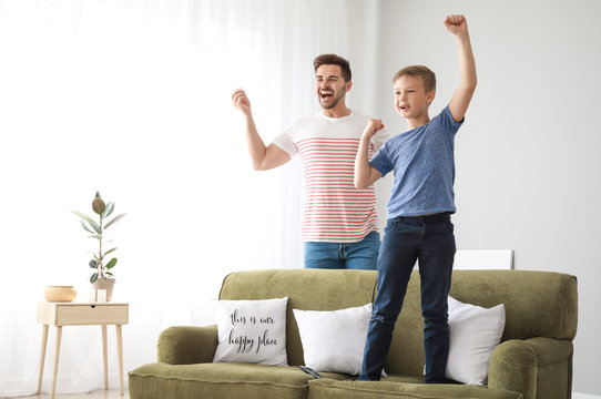 Father with son watching sports on TV at home