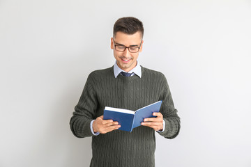 Handsome male teacher with book on white background