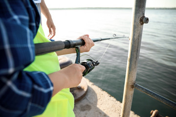 Father and son fishing together on river, closeup