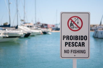 Sign saying "Proibido pescar" (No fishing) at the marina in Vilamoura, Algarve, Portugal