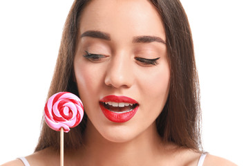 Beautiful young woman with bright lipstick and lollipop on white background