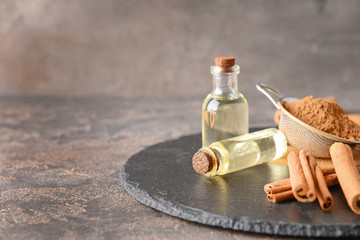 Obraz na płótnie Canvas Aromatic cinnamon sticks, essential oil and powder on table