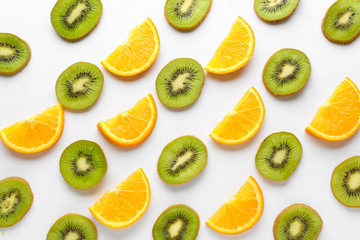 Slices of ripe kiwi and orange on white background