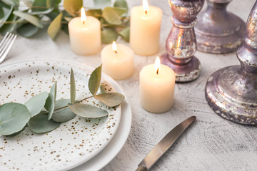 Fototapeta na wymiar Beautiful table setting with burning candles and floral decor