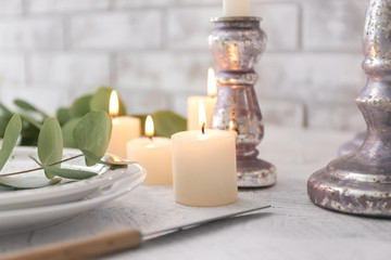 Fototapeta na wymiar Beautiful table setting with burning candles and floral decor, closeup