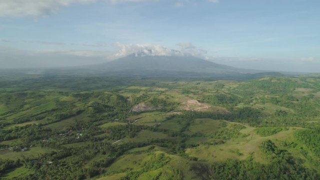 Aerial view mountain valley with hills covered forest, trees, mount Iriga. Luzon, Philippines. Slopes of mountains with evergreen vegetation. Mountainous tropical landscape.