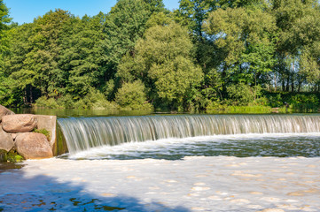 Photo of natural beautiful waterfall in summer on a sunny day in the forest. Great day, nice weather.