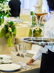 Waiter decorate and setting luxury party dinner table in restaurant.