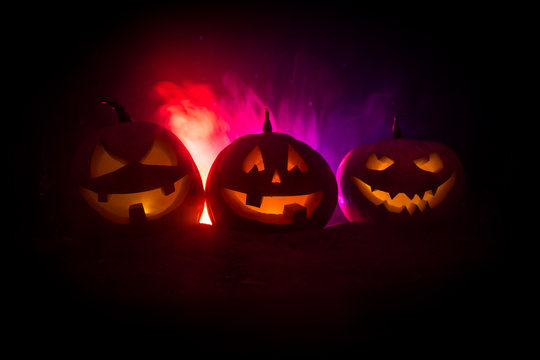 Group of Halloween Jack o Lanterns at night with a rustic dark foggy toned background